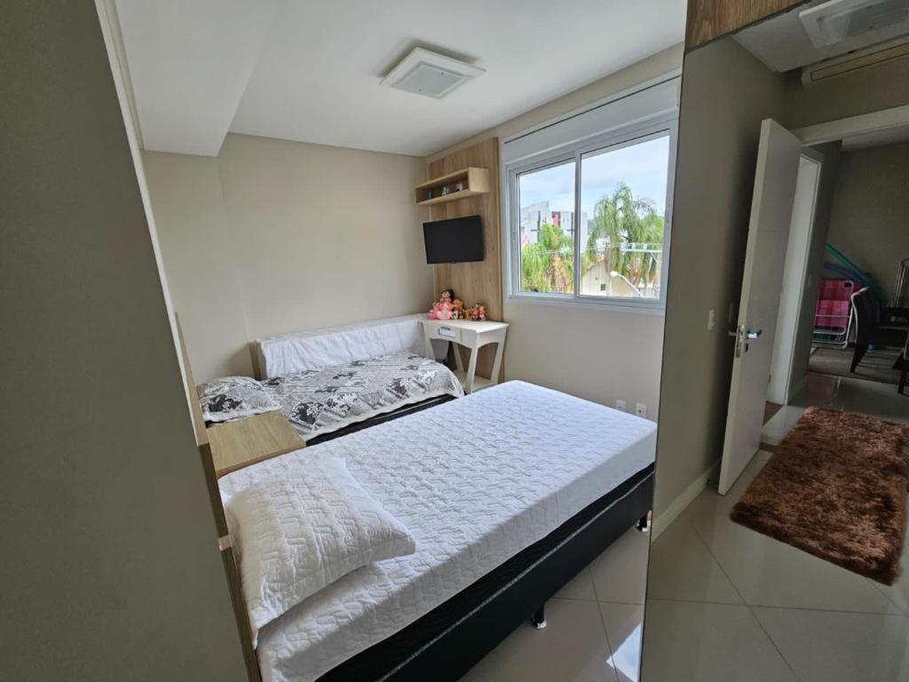 - une petite chambre avec un lit et une fenêtre dans l'établissement Apartamento em Canasvieiras, à Florianópolis