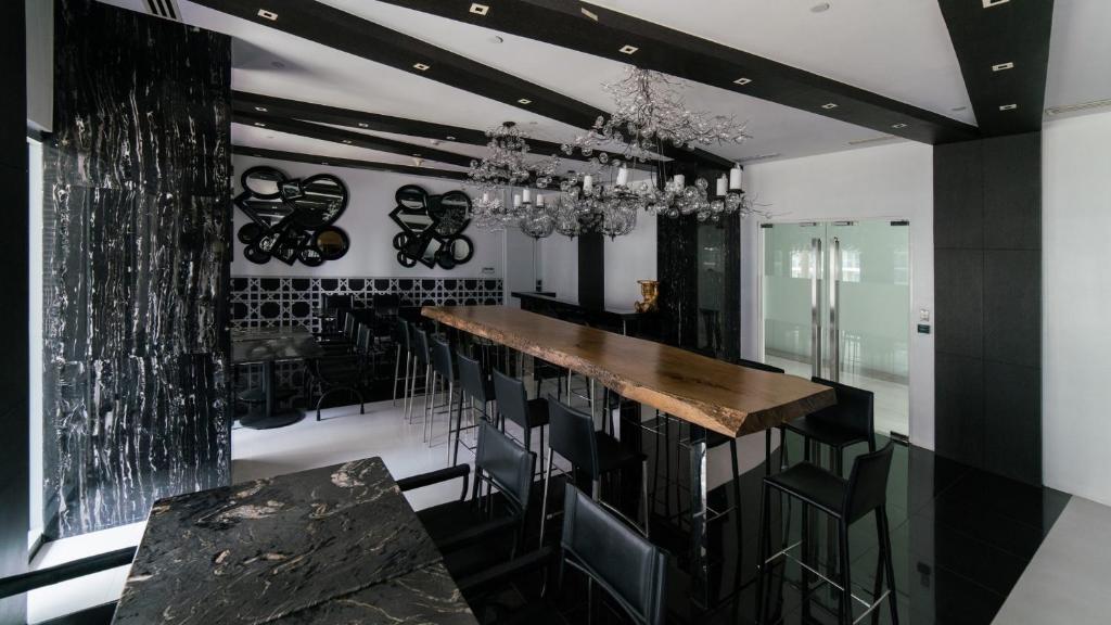 a black and white kitchen with a bar with stools at Great for Staycation for Family in Azure Beach in Tanza