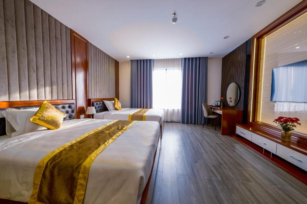 ein Hotelzimmer mit 2 Betten und einem Fenster in der Unterkunft MIMOSA HOTEL in Hạ Long