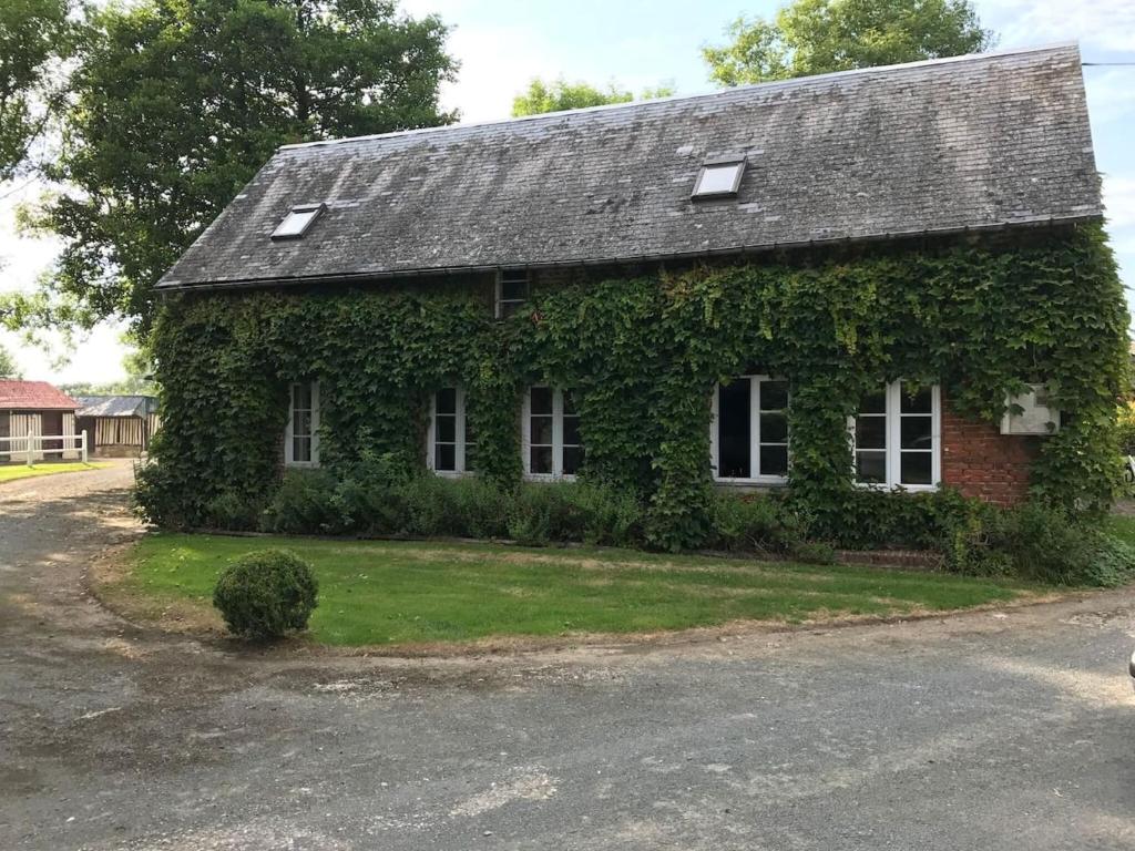 una casa cubierta de hiedra a un lado de la carretera en Maison de 3 chambres a Annebault, en Annebault