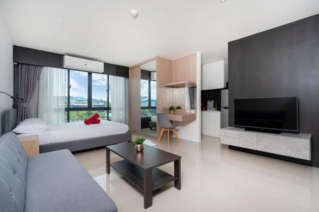 ein Wohnzimmer mit einem Bett, einem Sofa und einem TV in der Unterkunft Central Hill View Condo A920 B with Prime Location in Ban Ket Ho