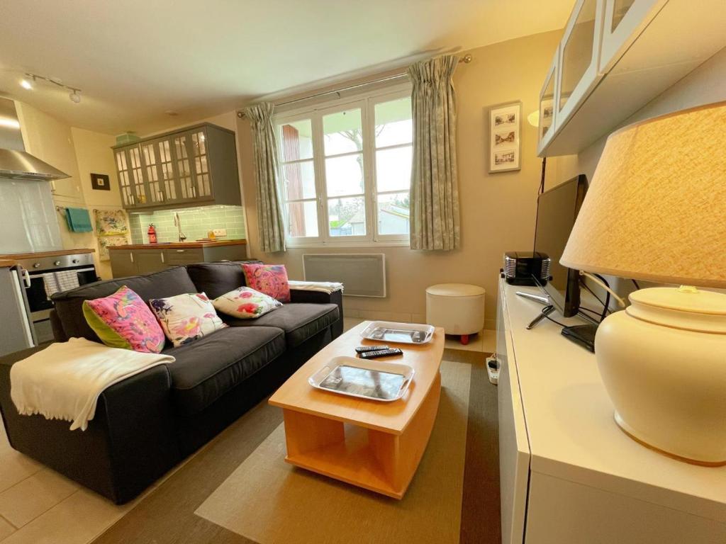 un soggiorno con un divano e un tavolo di Gîte tout inclus avec jardin privatif, proche centre Richelieu et châteaux de la Loire - FR-1-381-565 a Richelieu
