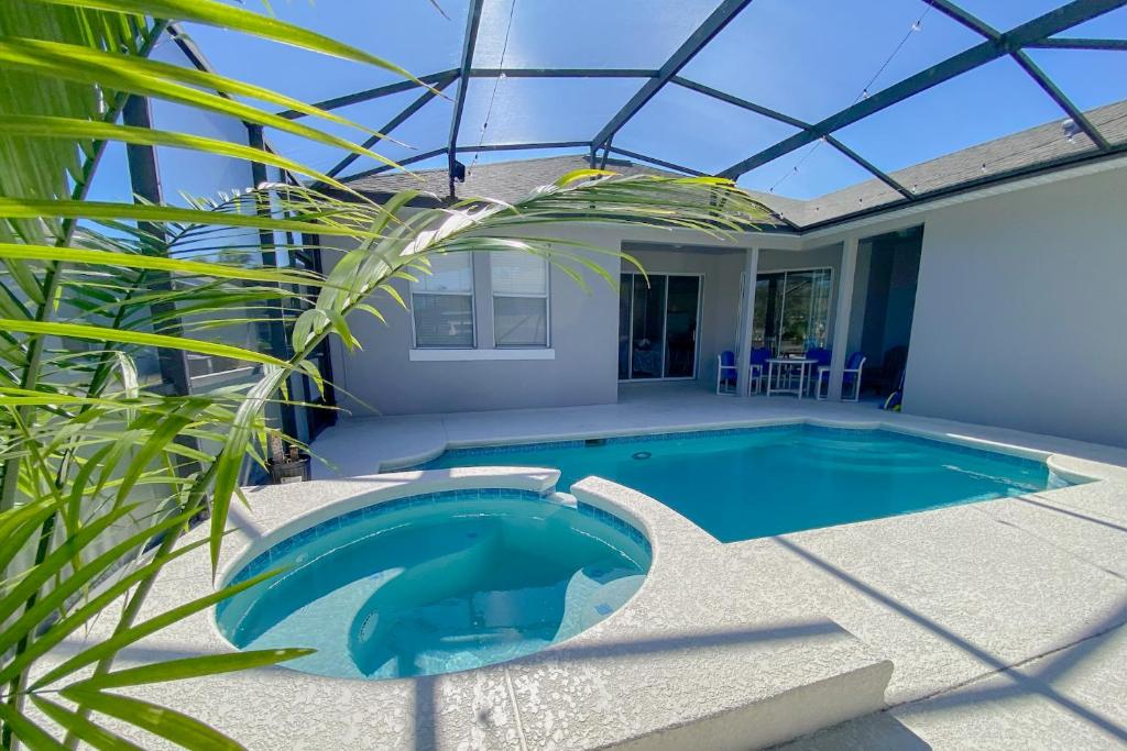 une piscine dans une maison avec un toit en verre dans l'établissement Family Vacation House at Resort, à Kissimmee