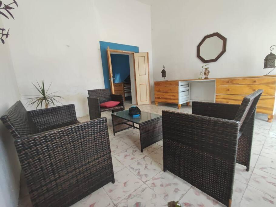 ein Wohnzimmer mit Korbstühlen und einem Tisch in der Unterkunft Pequeña casa en el centro de Mérida in Azcorra