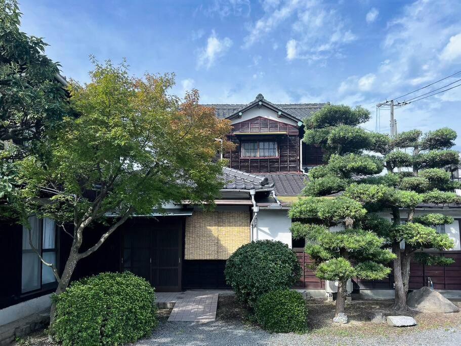 een huis met bomen ervoor bij ひねもす101:宇野駅から車で5分 直島へ 最大8名様 古民家 in Tamano
