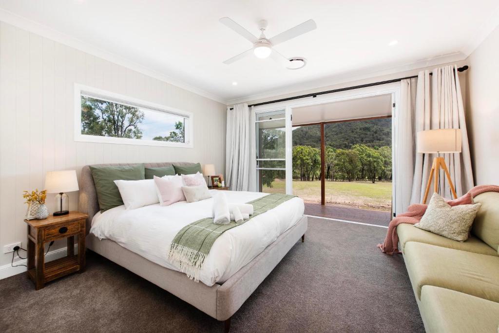 a bedroom with a large bed and a couch at Lazy Frog Lodge Mudgee country luxury in Mudgee