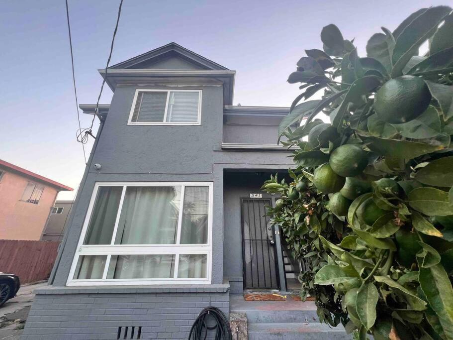 una casa gris con ventanas blancas y un árbol en Charming Victorian Vacation Rental - Walking Distance BART, en Oakland