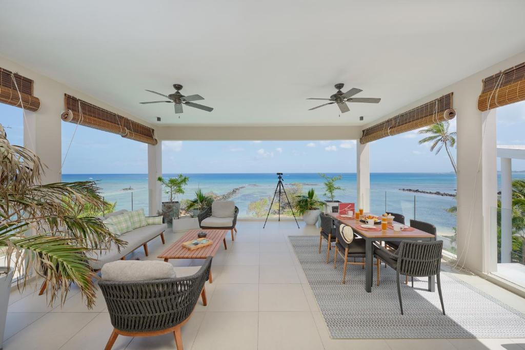 a dining room with tables and chairs and the ocean at Otera 2 Penthouse with panoramic view by LOV in Trou aux Biches