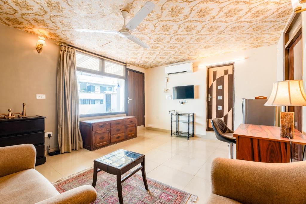 uma sala de estar com um sofá e uma mesa em Mystique abode em Nova Deli