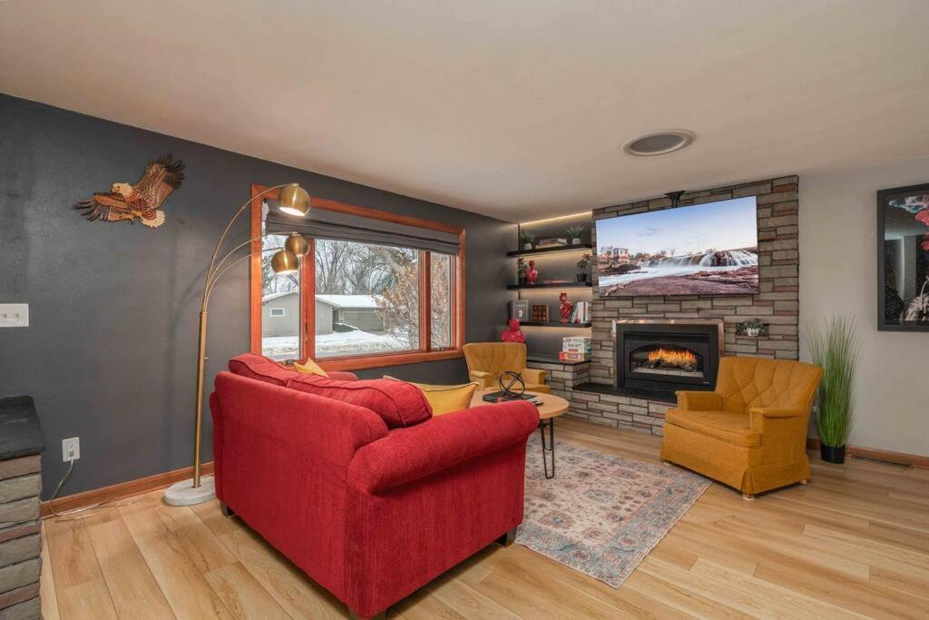 sala de estar con sofá rojo y chimenea en Brick House, en Sioux Falls
