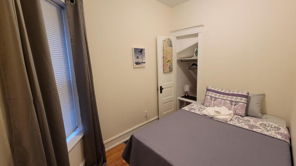 a small bedroom with a bed and a window at Chateau de Woodlawn - Room III - The Dream Catcher in Chicago