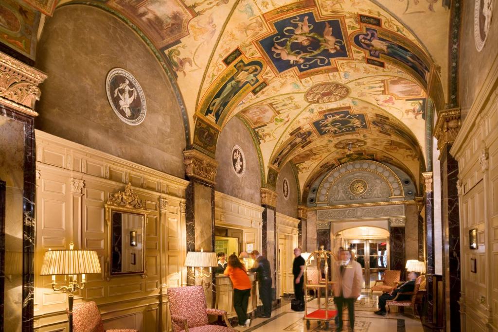 un groupe de personnes traversant un bâtiment avec plafond dans l'établissement The Sherry Netherland, à New York