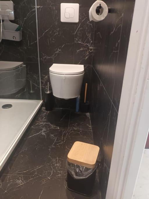 a black bathroom with a toilet and a sink at La Marée, Studio vu mer Le Havre in Le Havre