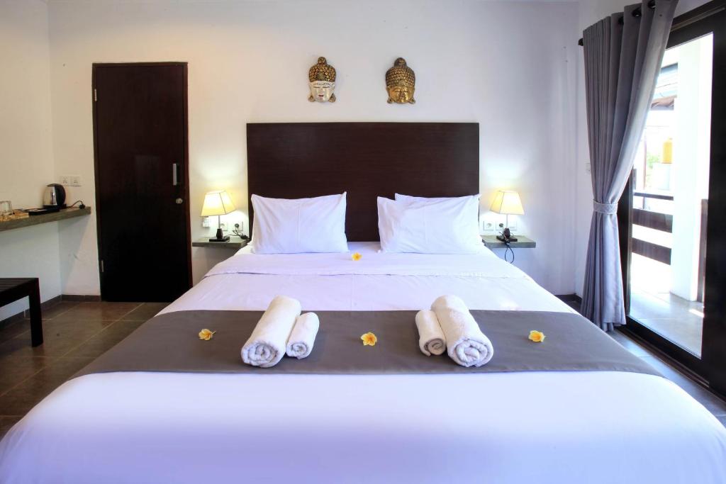 1 dormitorio con 1 cama blanca grande y toallas. en Gili Ocean Club - ADULTS ONLY, en Gili Trawangan