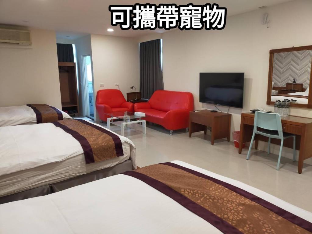 um quarto de hotel com duas camas e uma televisão de ecrã plano em Hai Gang Yuan Homestay em Kenting