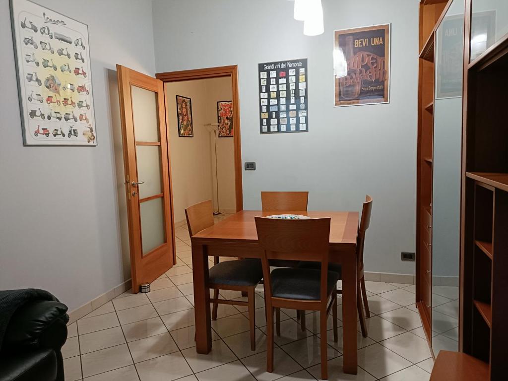 LELLO'S HOUSE في تورينو: غرفة طعام مع طاولة وكراسي خشبية