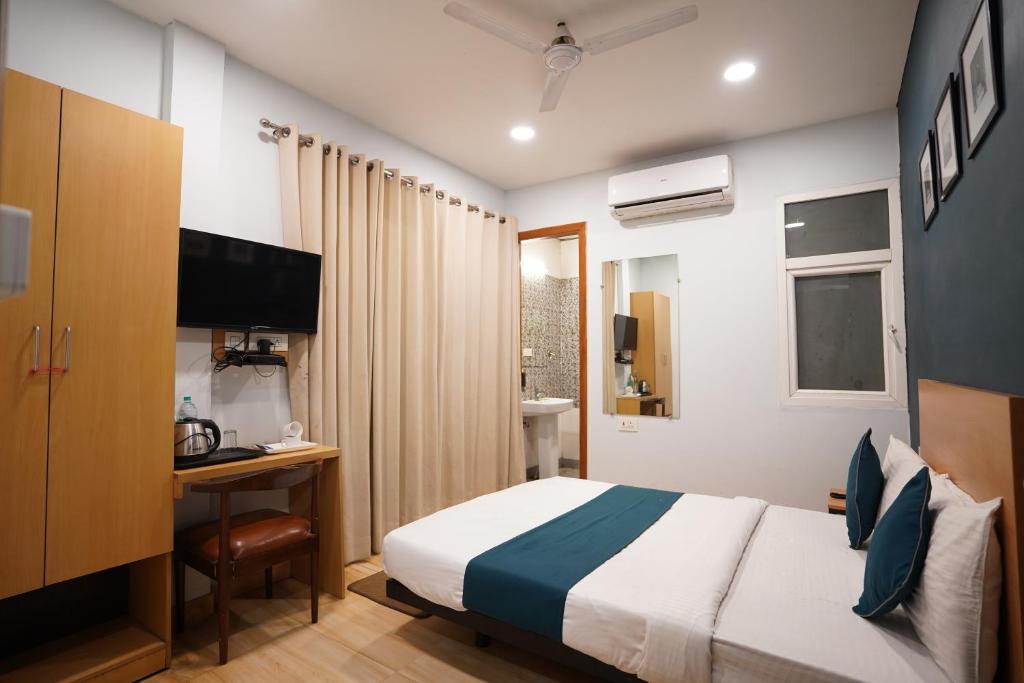 1 dormitorio con 1 cama y escritorio con ordenador en Hotel Lyf Corporate Suites Meera Bagh en Nueva Delhi