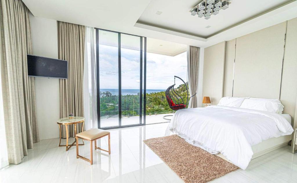 a bedroom with a large bed and a large window at Villa Savoy Sharm Samui in Chaweng Noi Beach