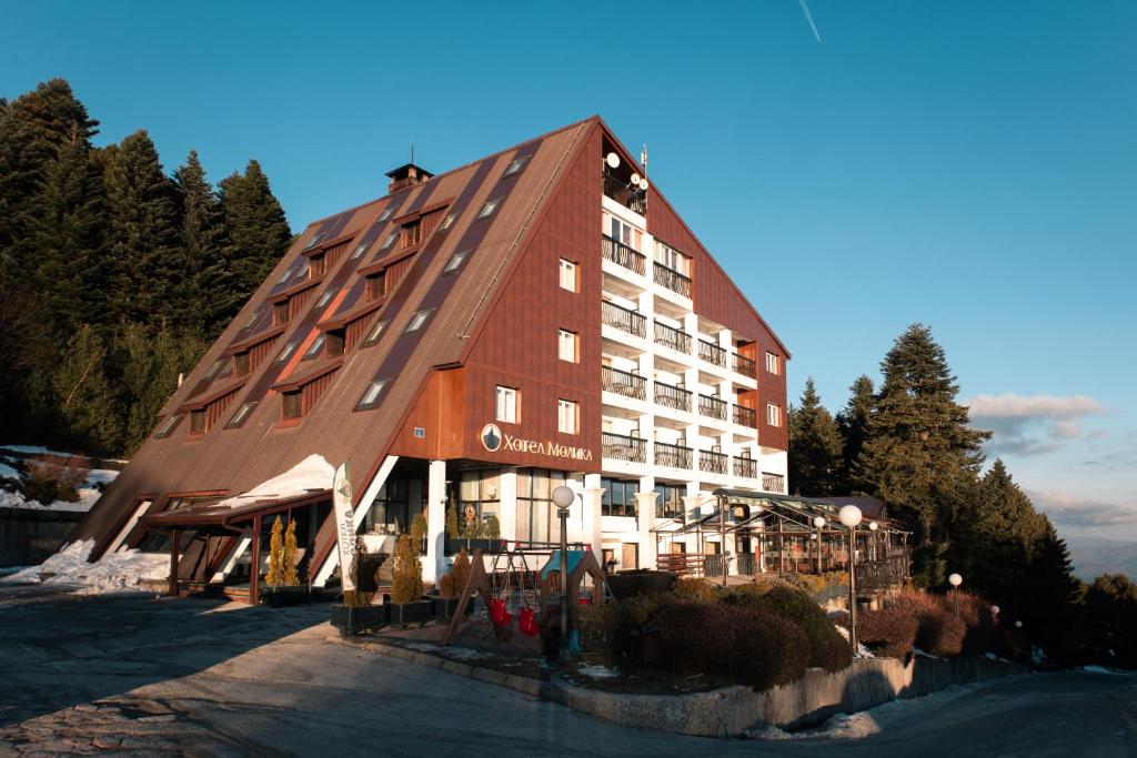a large hotel with a large wooden building at Hotel Molika in Magarevo