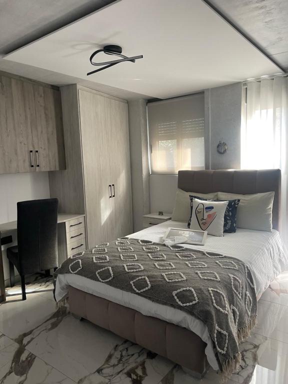 - une chambre avec un lit et un ventilateur de plafond dans l'établissement Sea View Apartment, à Patras