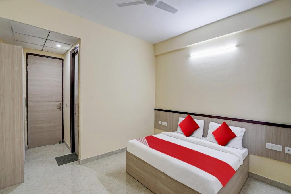 a bedroom with a large bed with red pillows at Flagship Mt Corporate Suites Pari Chowk Near Pvr Ansal Plaza Greater Noida in Greater Noida