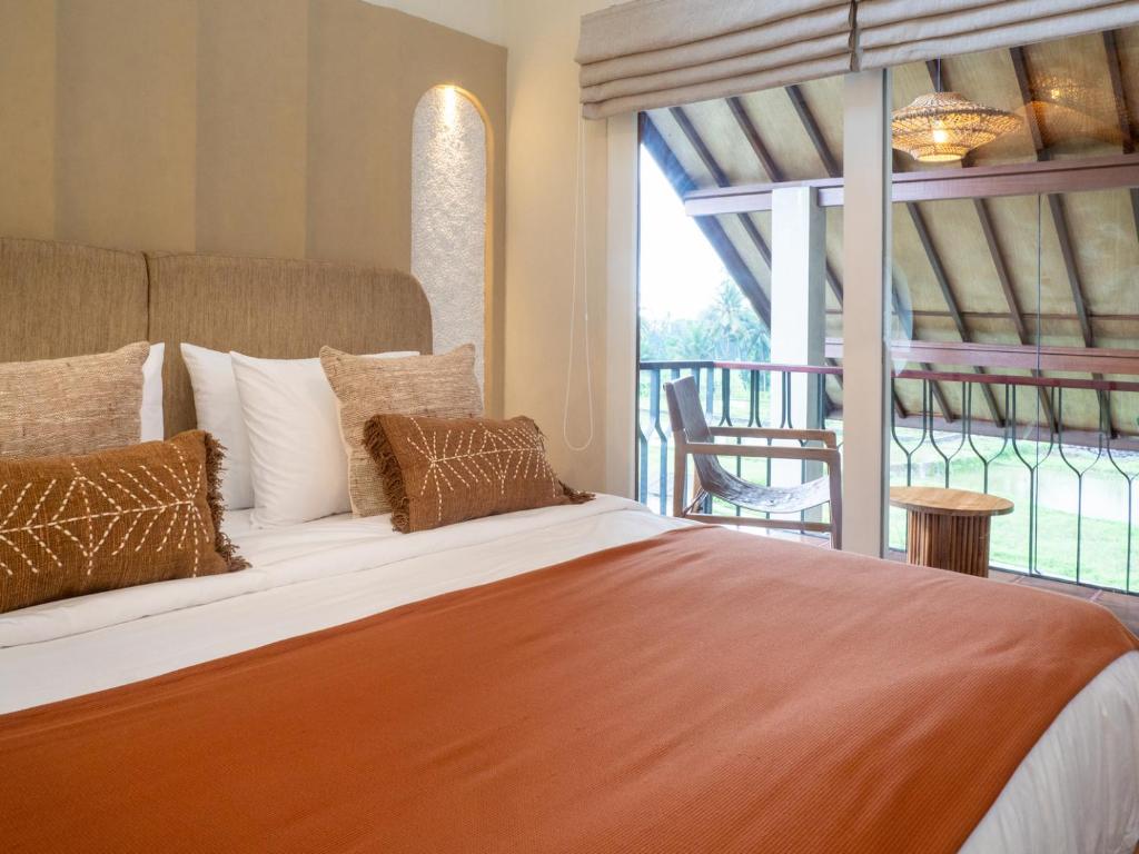 a bedroom with a large bed and a balcony at Tarate Loft Studio Ubud in Ubud