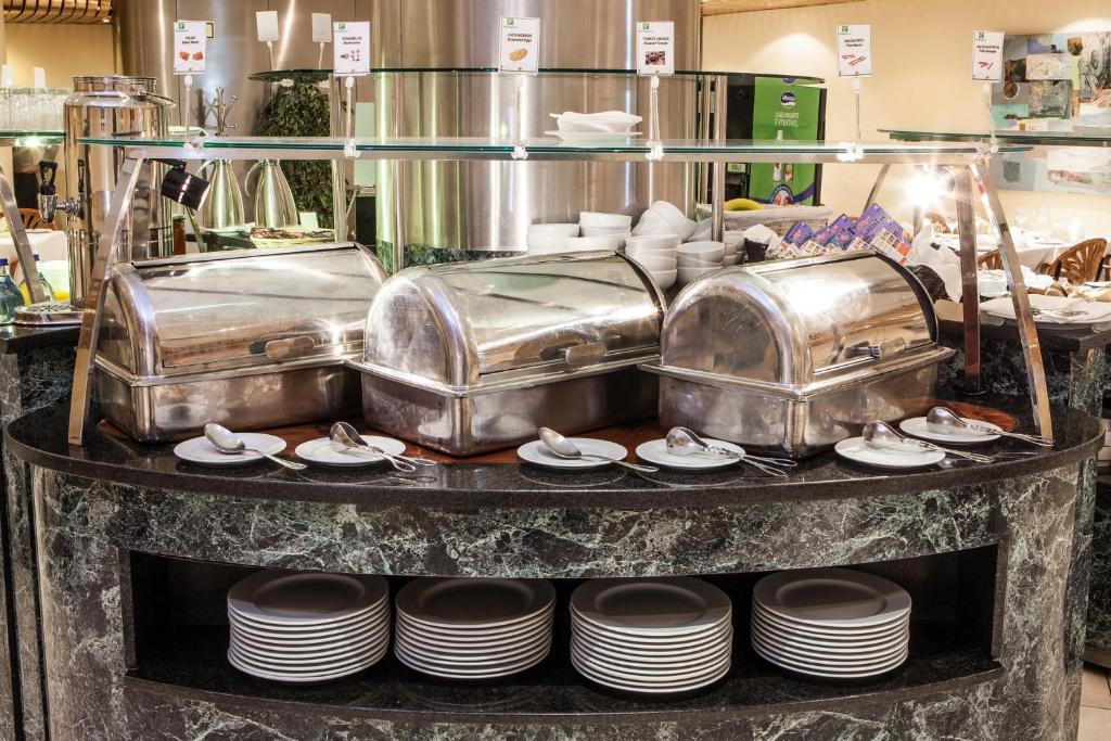 A hot buffet station with covered serving dishes and stacked plates.