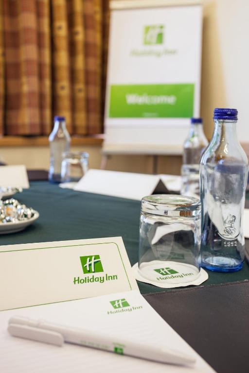 A close-up of a meeting table set with water, stationery, and a laptop.