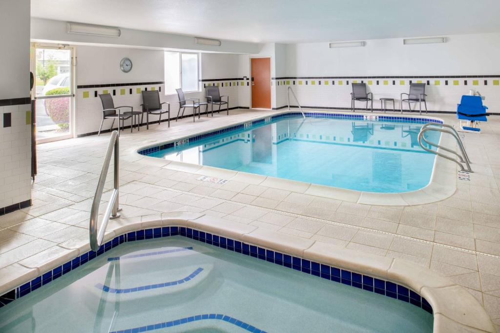 una piscina en un hotel con sillas y mesas en Fairfield Inn Spokane Downtown en Spokane