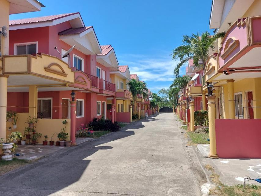 an empty street with colorful houses and palm trees at Vacation Town House Near Mactan Cebu Airport in Mactan