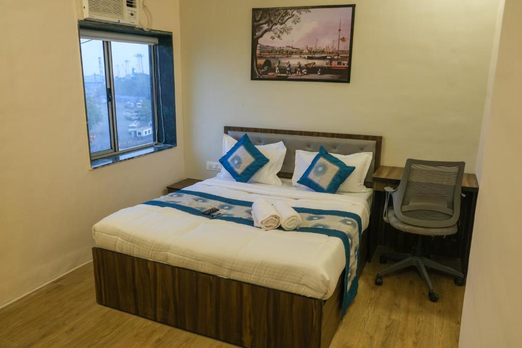 a bedroom with a bed with a desk and a chair at VR Comforts in Mumbai