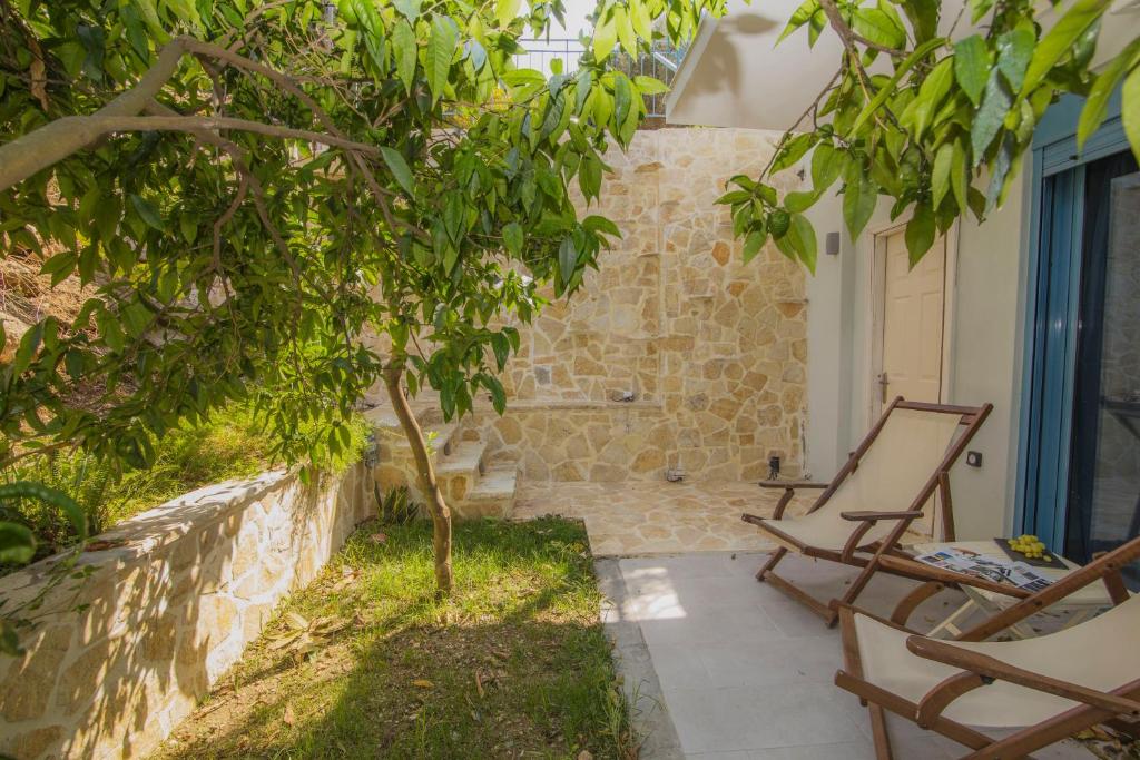 un patio con 2 sedie e un albero di AκrotiriResort a Vassiliki