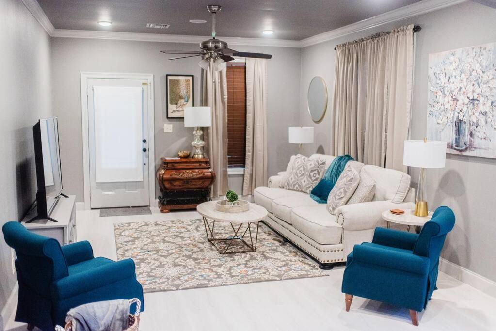 a living room with a couch and two blue chairs at Country Cottage - Broussard in Broussard