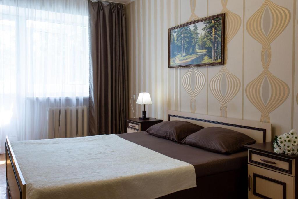 sypialnia z łóżkiem i zdjęciem na ścianie w obiekcie Апартаменты возле метро Ботанический сад w Charkowie