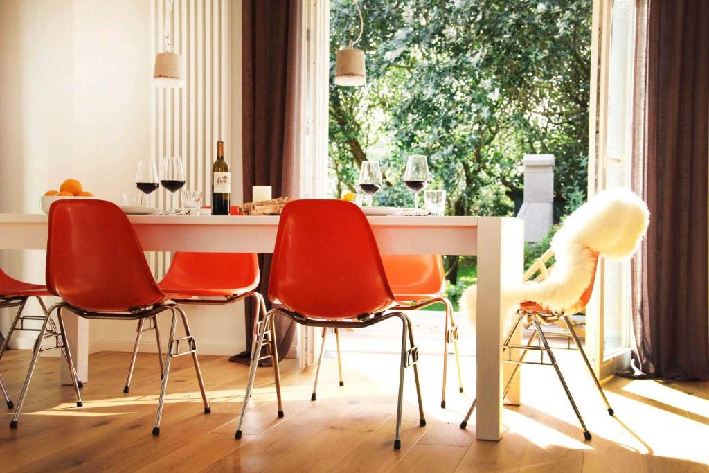 a dining room with red chairs and a white table at Strandhaus in Hörnum