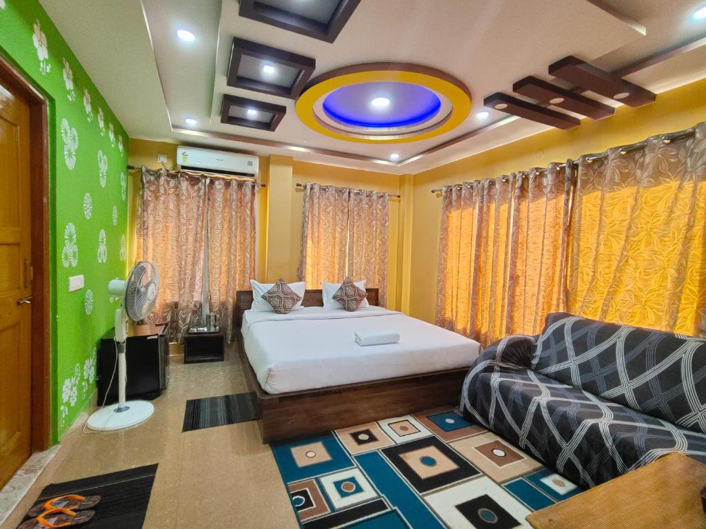 a bedroom with a bed and a couch at Hotel Green Wood in Siliguri