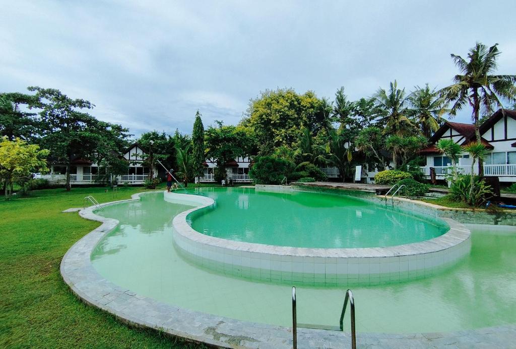 a large swimming pool in the middle of a yard at RedDoorz @ Padi Beach Resort Oton Iloilo in Oton