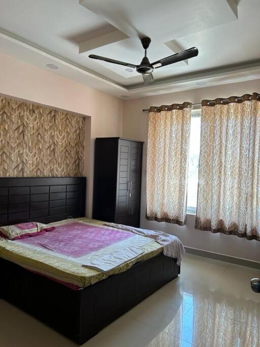 a bedroom with a large bed in a room with windows at Sukh sagar Lifestyle in Jabalpur
