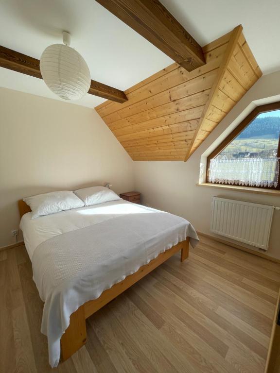 1 dormitorio con cama y ventana grande en PrzyStań w Gorcach, en Konina
