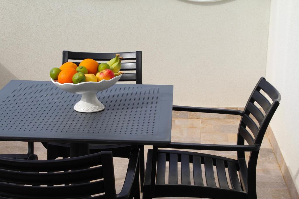 a bowl of fruit on a table with two chairs at Hotel Opera Jaz in Budva