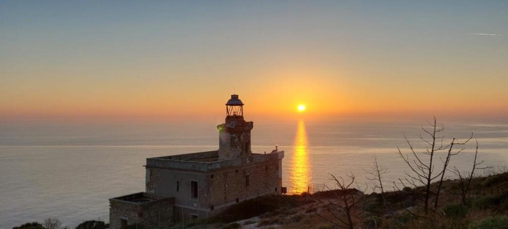 a lighthouse on a hill with the sunset in the background at Relais Al Faro Bed&Breakfast in San Domino
