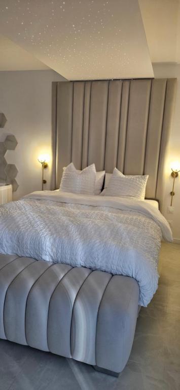 a bedroom with a large bed with white sheets and pillows at Douceur Dorée in Yville-sur-Seine