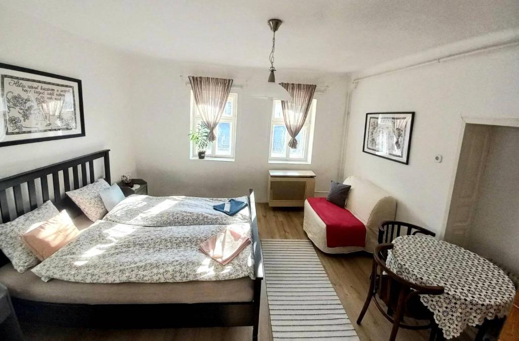 una camera da letto con un letto, un tavolo e una sedia di Lankás Vendégház - Hollókő a Hollókő