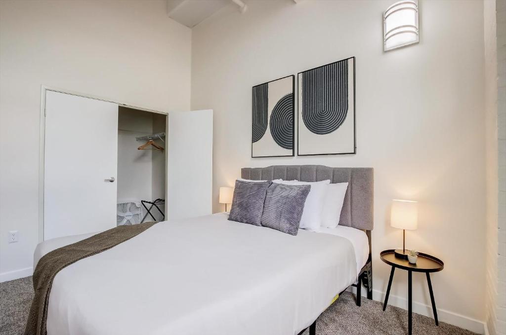 印第安納波利斯的住宿－TWO CozySuites Apartment with Skybridge Access #4，卧室配有一张白色大床和两盏灯。