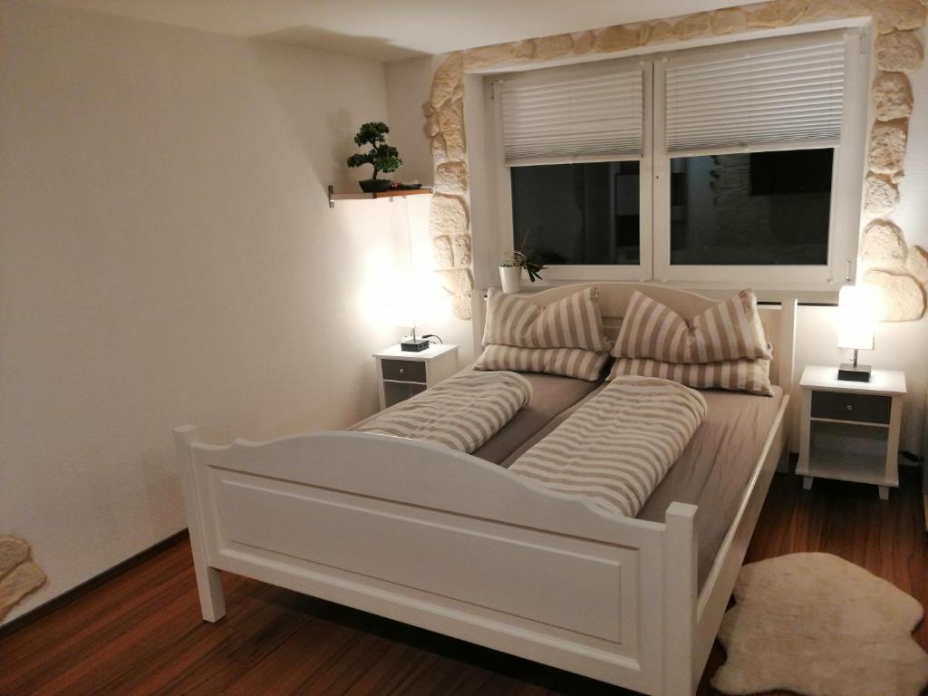 a large white bed in a room with a window at Ferienwohnung Hecht - Relax or work in nature in Wolfegg