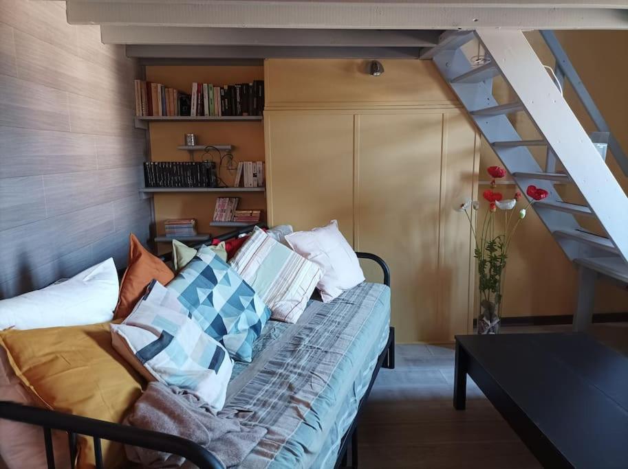 Cette chambre dispose d'un canapé avec des oreillers et d'un escalier. dans l'établissement Côte & Mer, à Criel-sur-Mer