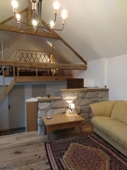 a living room with a couch and a table at Superbe appartement dans charmant corps de ferme in Achères-la-Forêt