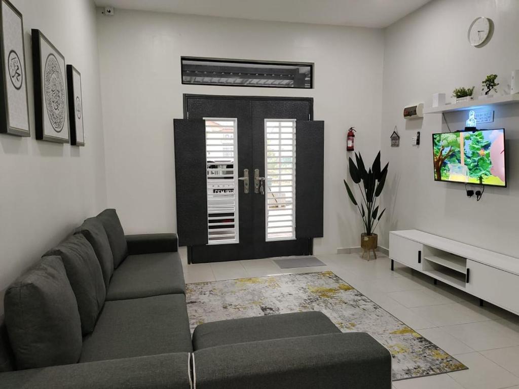 Firdzura Home Semi D في كُوانتان: غرفة معيشة مع أريكة وتلفزيون