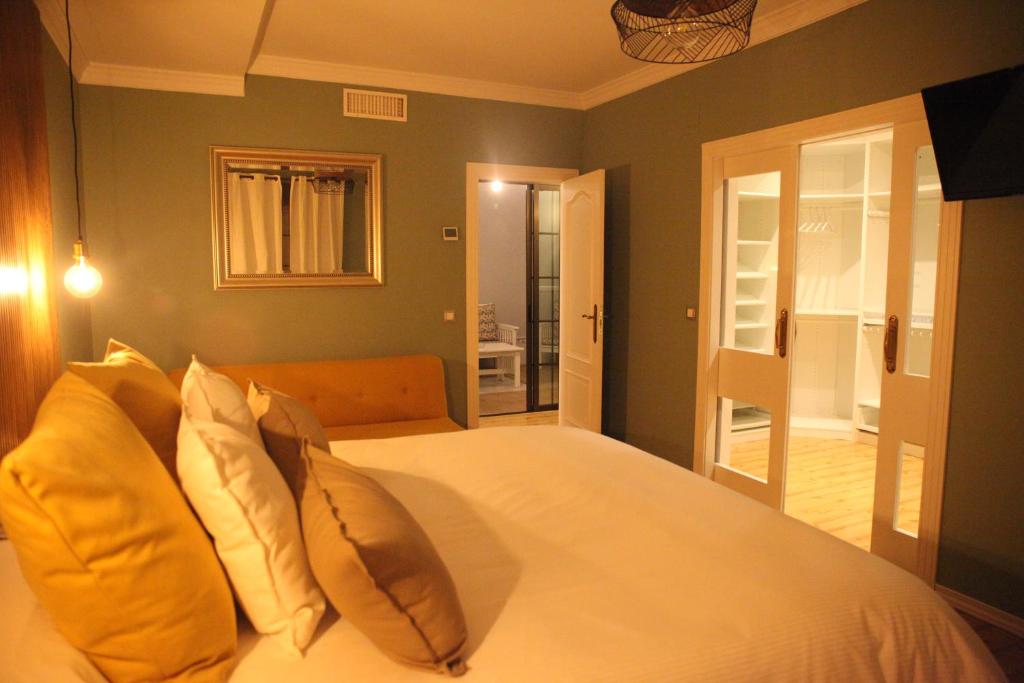 um quarto com uma cama grande e almofadas amarelas em La Parada de Posadas em Posadas