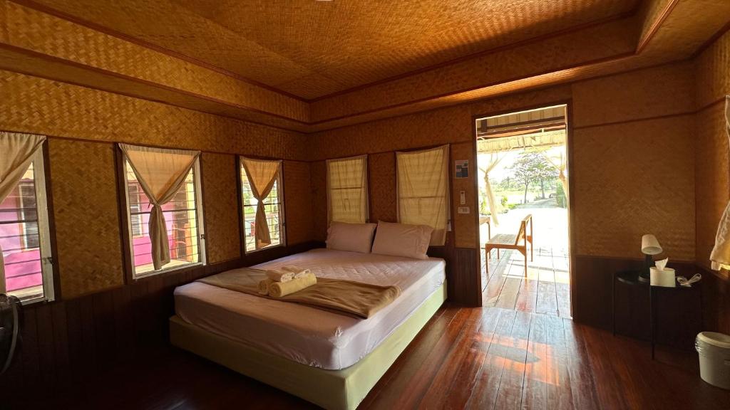 a bedroom with a bed in a room with windows at อิงน้ำท่าจีน (ท่าจีนรีสอร์ท) in Suphan Buri